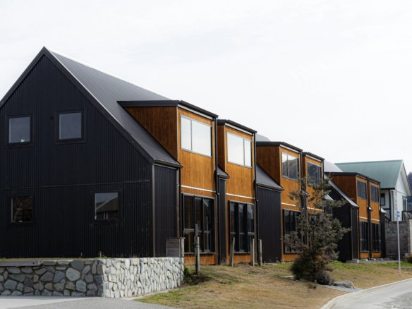 a row of houses on a street with mountains in the background